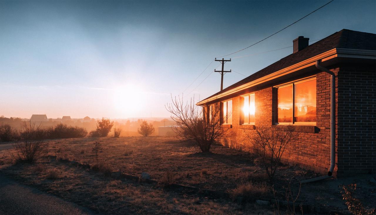 Low evening sun blazing against the west-facing windows of a brick home